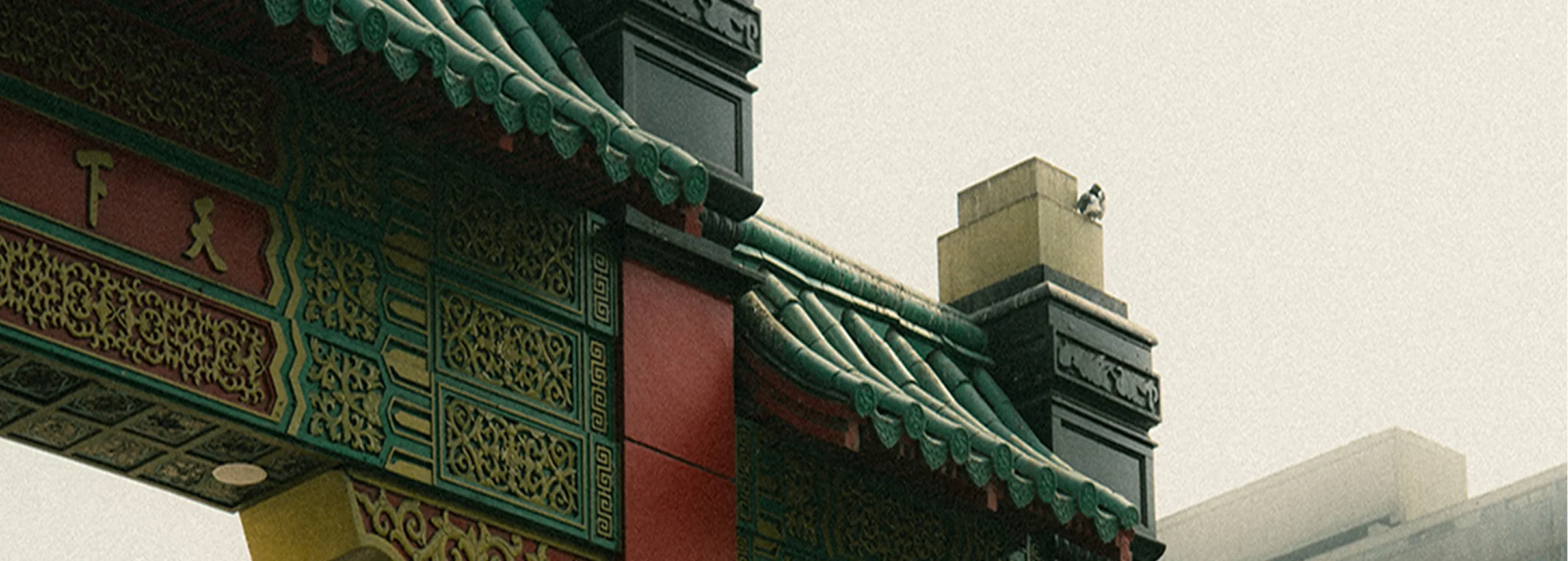 Detail of a traditional Chinese archway with green tiled roof.